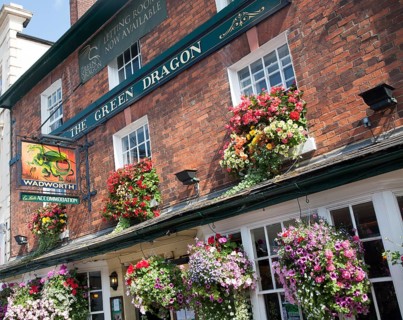 Exterior sign and floral display outside the Red Dragon pub in Marlborough, Wiltshire, England,
