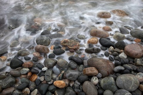Stones on the beach with running water, Sommarøy, Norway, Europe