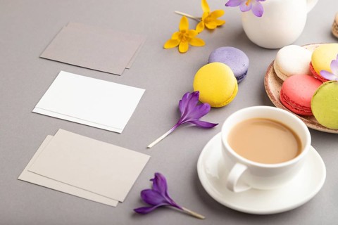 Gray and white business card mockup with spring snowdrop crocus flowers, cup of coffee,