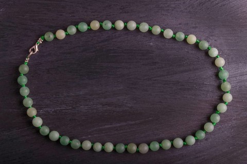 Green agate colored beads on a black background. top view, close up