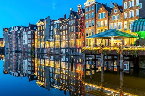 Canal houses on the Damrak, in the centre of the old town of Amsterdam, harbour, starting point of