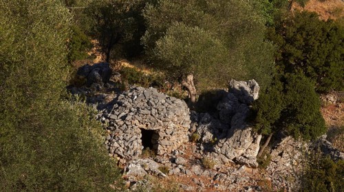 Koumas, traditional stone shelter for shepherds, an old stone ruin nestled among trees in a green