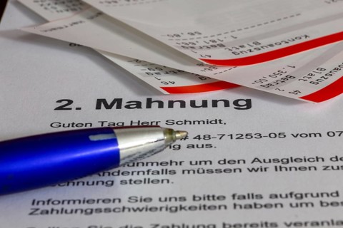 Symbolic image of debt, over-indebtedness: Close-up of bank statements and a reminder