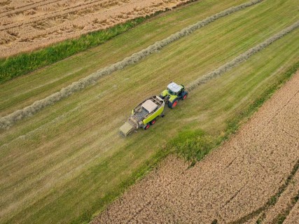 Tractor ploughing a field and preparing hay bales, Dachtel. Black Forest, Germany, Europe