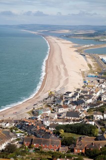 Chesil beach tombolo with housing in Chiswell in the foreground, Isle of Portland, Dorset, England,