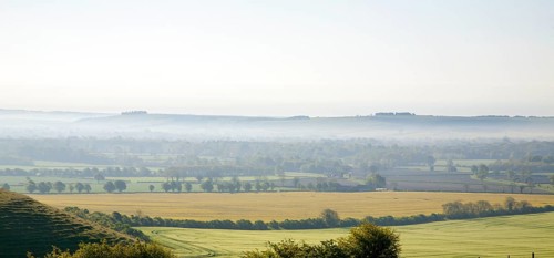 Early morning ground fog lying over fields in the Vale of Pewsey, near Alton Barnes, Wiltshire,