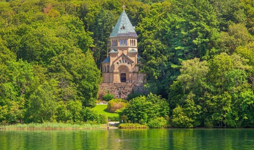 Votive chapel Memorial Chapel of St Ludwig on the lakeshore with wooden cross in the lake, the