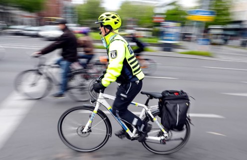 A policewoman from the Berlin bicycle squadron accompanies the bike parade demonstration, Berlin,