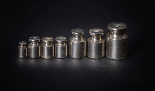 A set of small metal weights on a gray background