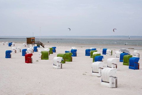 Beach chairs on the sandy beach, DLRG watchtower, kitesurfer on the North Sea, Utersum, Föhr, North