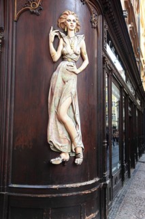 Scantily clad young woman as a facade decoration on a shop in Karlsgasse, Old Town, Prague, Czech