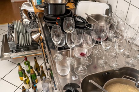 Kitchen after a big dinner, cooking party, dishwasher, full, with cleaned dishes, dirty glasses,