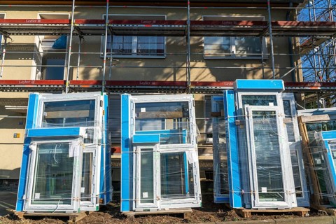 Energy-efficient refurbishment of residential buildings, older apartment block is scaffolded, gets