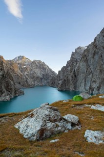 Wild camping, camping in the wilderness with a tent in front of mountain lake Kol Suu, Sary Beles