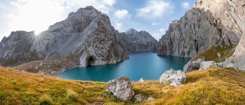 Mountain lake Kol Suu with rocky steep mountains, Sun Star, Kol Suu Lake, Sary Beles Mountains,