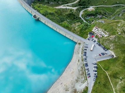 Dam of the Moiry lake, Lac de Moiry, turquoise glacial water, parking lot and restaurant at the