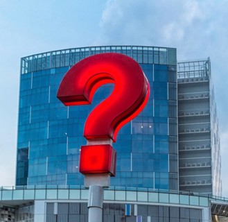 Red question mark on the streets of Singapore with a modern building in the background