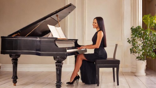 A pianist in a black dress plays serenely on a piano in an elegantly decorated interior, AI