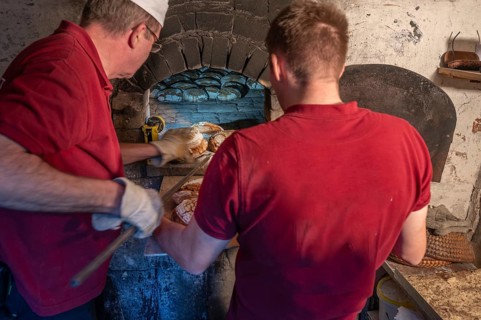 Freshly baked wood-fired bread is taken out of the wood-fired oven, Franconia, Bavaria, Germany,
