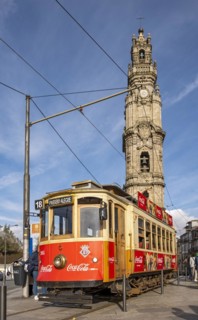 The iconic red tram number 18 pauses in front of the Clérigos Church Tower, Porto, Portugal, Europe