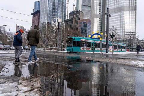 Winter in the city, Gallusanlage street, puddles, pools of water, melt water, pedestrians,