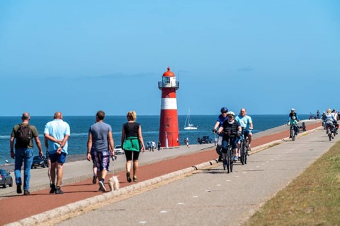 North Sea dyke near Westkapelle, Westkapelle Laag lighthouse, cyclists on the Zeeuwse Wind Route