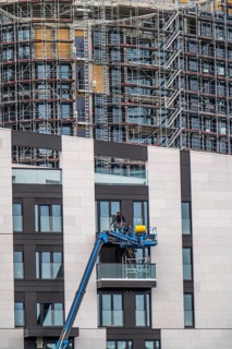 Large construction site, construction of a high-rise residential building, scaffolded shell,