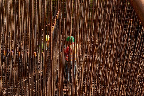 Construction site, reinforced concrete construction site, workers erect a mesh of reinforcing bars,