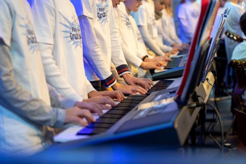 Young people, children play on many keyboards, simultaneously, electronic clarinet, at a concert