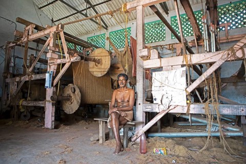 Indian worker, 68 years old, sitting in the weaving mill of the Labourers Coir Mats and Mattings