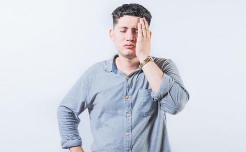 Exhausted person putting the palm of his hand on his face. Tired and exhausted man covering his