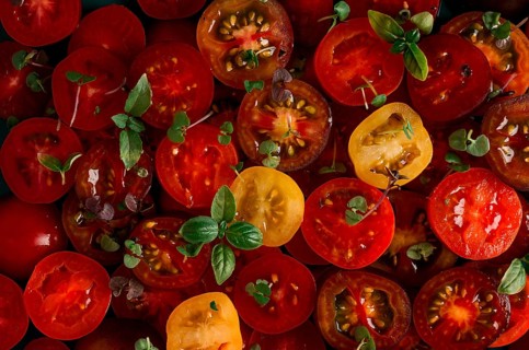 Colored, yellow, red, black, sliced cherry tomatoes, with basil, close-up, top view, no people,