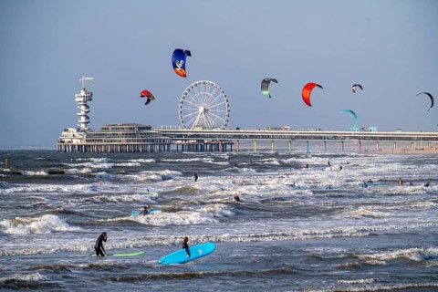 The pier and Ferris wheel at Scheveningen beach, strong swell, windsurfers, kitesurfers, surfers,