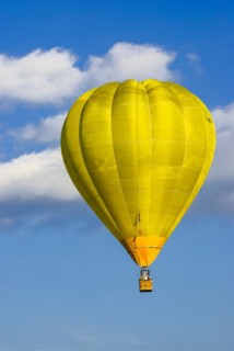 A yellow hot air balloon rises into the air as part of the aviation festival on the Rossfeld in
