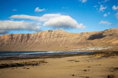 Late afternoon light on beach and cliffs La Caleta de Famara, Lanzarote, Canary islands, Spain,