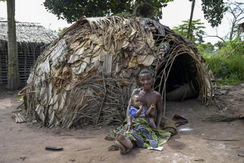 Pygmy woman of the Baka or BaAka people with her child in front of her hut, Bayanga, Sangha-Mbaéré