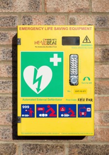 Automated External Defibrillator emergency life saving equipment mounted on wall, Community