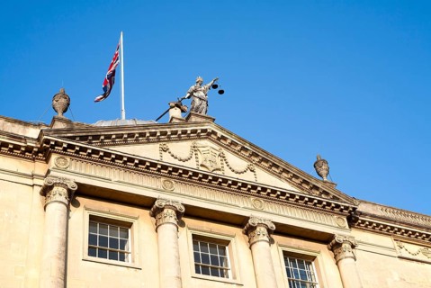 Union Jack flag flying with Britannia holding scales of Justice, top Guildhall building, Bath,