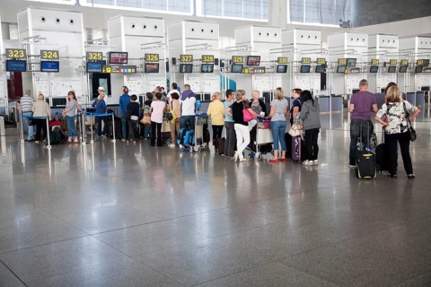 People waiting to check in inside Malaga airport, Spain, Europe