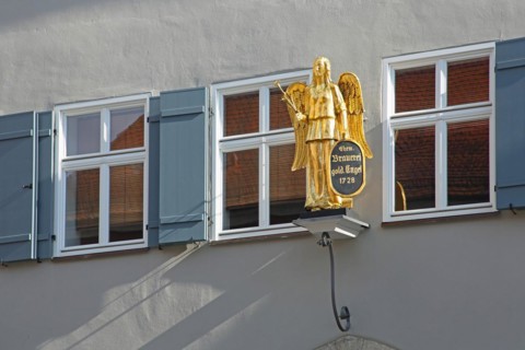 House wall with three windows and nose sign of the brewery Goldener Engel Gasthof, sculpture,