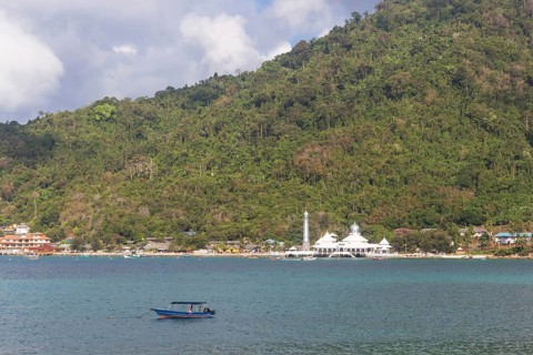 Green tropical island with a mosque on the coast.Malaysia