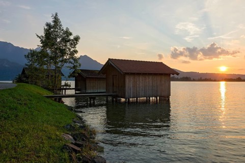 Boat huts with wooden jetty, lakeside promenade, sunset on Lake Kochel near Kochel am See, Bavarian