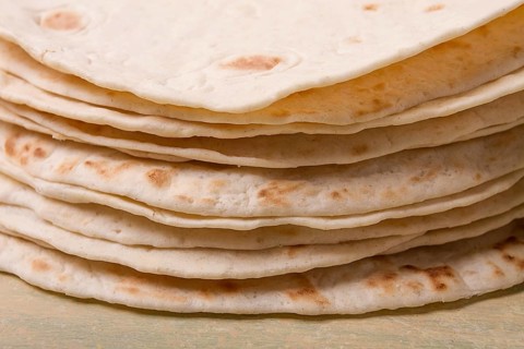 A stack of Mexican tortillas, on a gray table, top view, close-up, no people