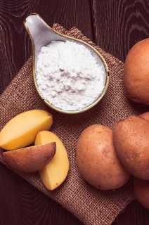 Potato starch, on a wooden table, close-up, rustic style, no people, potatoes, ceramic spoon,