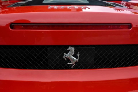 Close-up detail of red rear end of sports car Supercar Ferrari Spyder with logo trademark of luxury