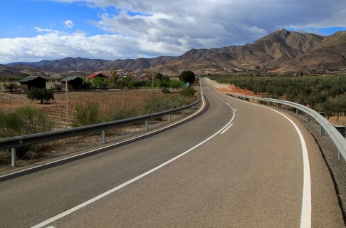 Modern road leading to mountains of Sierra de Baza range near village of Uleila del Campo, Almeria,
