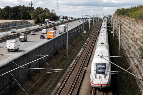 A Deutsche Bahn ICE train passes cars on the A3 motorway, Flörsheim, 28/09/2020