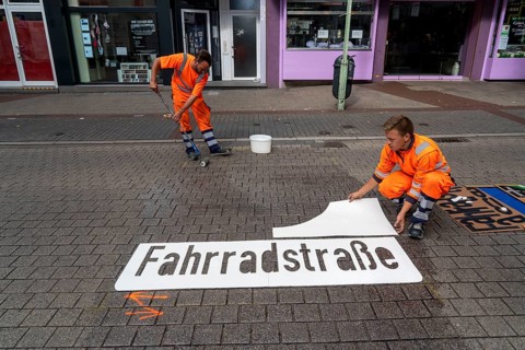 Application of road markings for a cycle lane, Rüttenscheider Straße in Essen, in the shopping and