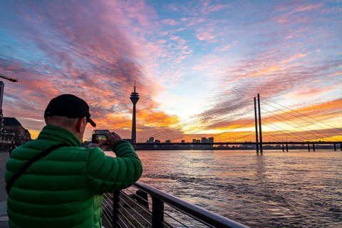 Winter sunset on the Rhine near Düsseldorf, riverside promenade at the old town, Rhine Tower, cargo