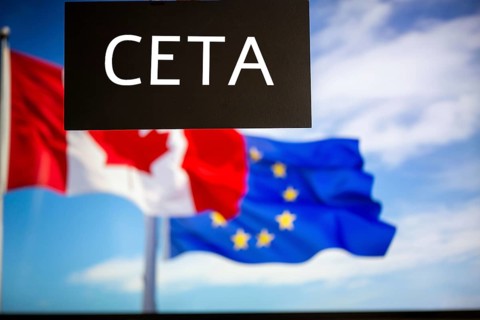 Sign reading CETA in front of the flags of Canada and the European Union. The abbreviation CETA